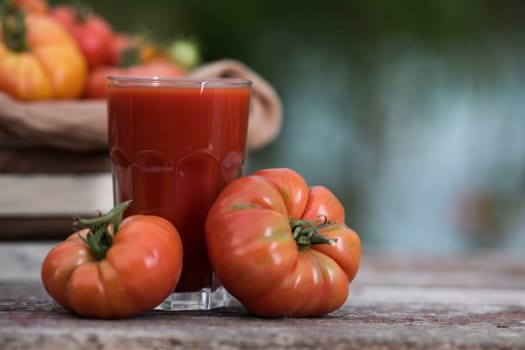 Fresh red tomato juice, on a wooden background
