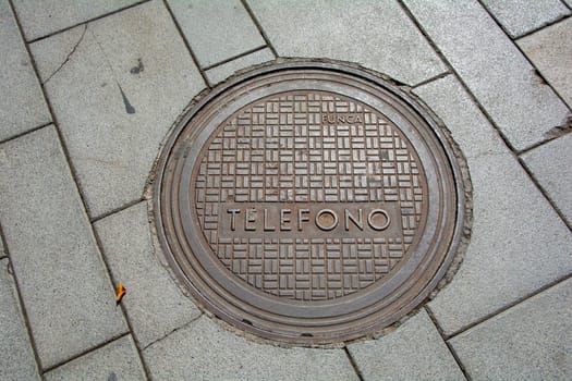 Costa Adeje, Tenerife, Spain August 12, 2022 - Manhole cover in a sidewalk