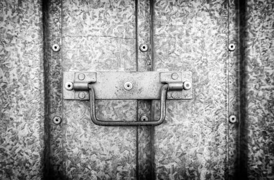 Detail of a metal handle to open and close a door on the street