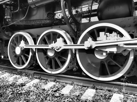 Retro train three wheels. Sleepers and rails, mechanisms, pistons and guides. Locomotive of the 19th early 20th century with a steam engine. Vintage style. Black - white photo. Beautiful card