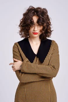 Studio portrait of tricky and playful woman with short curly hair