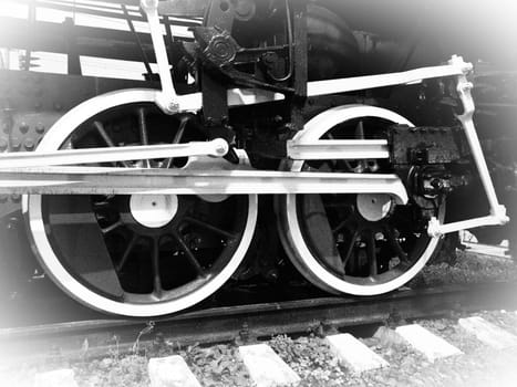 Retro train wheels. Beautiful card. Sleepers and rails, pistons and guides. Locomotive of the 19th early 20th century with a steam engine. Vintage style. Black-white. White vignetting around the edges.