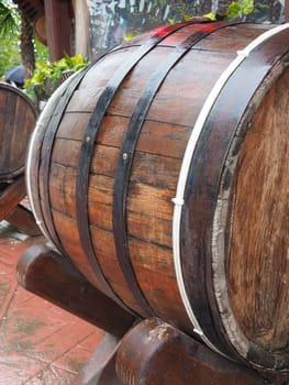A traditional old wooden barrel with curved walls and metal hoops. Dishes for the ripening of alcoholic beverages - mead, beer, wine, whiskey. A rollable cylindrical vessel for liquid substances