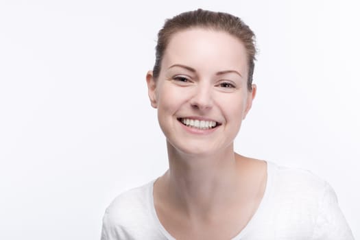 a young pretty woman in a white t-shirt smiles into the camera
