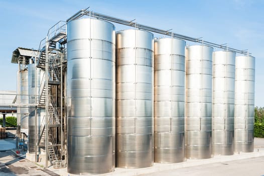 Industrial plant for storing wine, with stainless steel containers