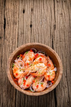 steamed shrimps in a wooden bowl on wood background
