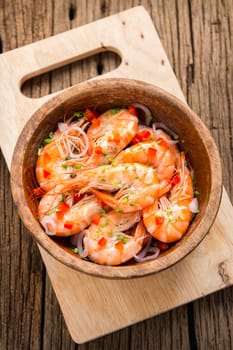 steamed shrimps in a wooden bowl on wood background