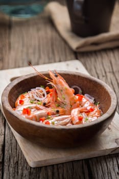 steamed shrimps in a wooden bowl on wood background
