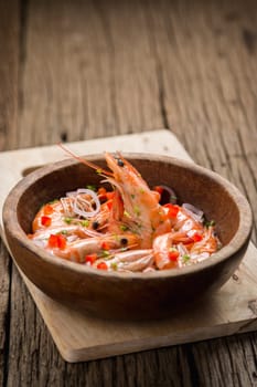 steamed shrimps in a wooden bowl on wood background