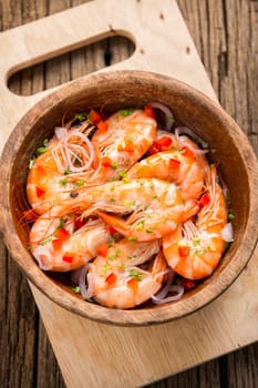 steamed shrimps in a wooden bowl on wood background