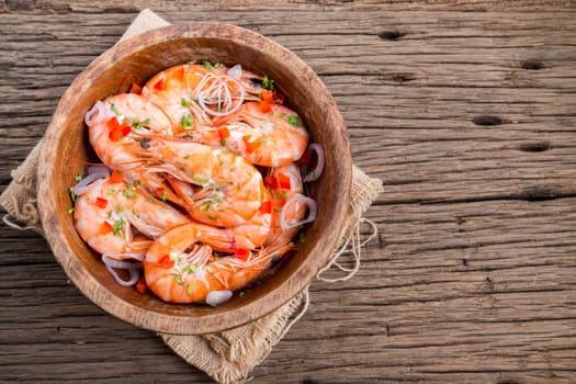 steamed shrimps in a wooden bowl on wood background
