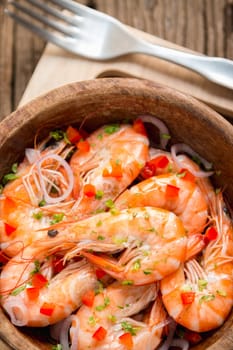 steamed shrimps in a wooden bowl on wood background