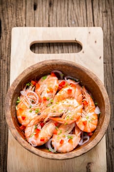 steamed shrimps in a wooden bowl on wood background