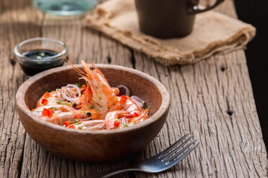 steamed shrimps in a wooden bowl on wood background