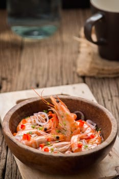 steamed shrimps in a wooden bowl on wood background
