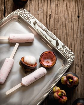 Ice cream containing mangosteen on a silver platter.