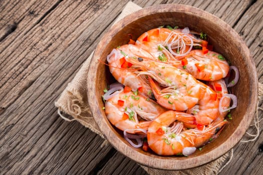 steamed shrimps in a wooden bowl on wood background