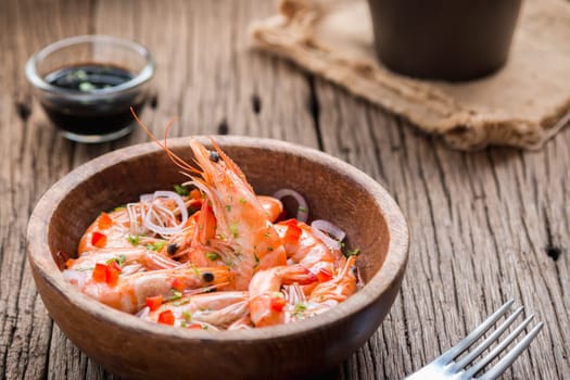 steamed shrimps in a wooden bowl on wood background