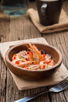 steamed shrimps in a wooden bowl on wood background
