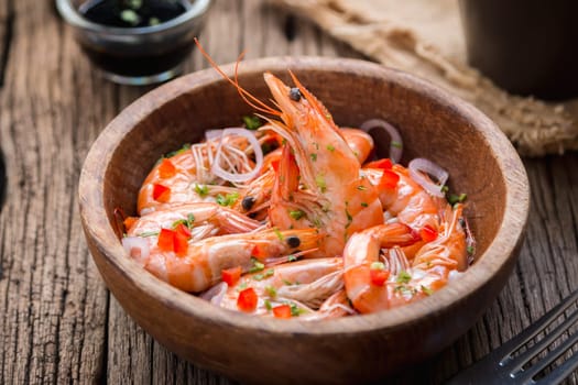steamed shrimps in a wooden bowl on wood background