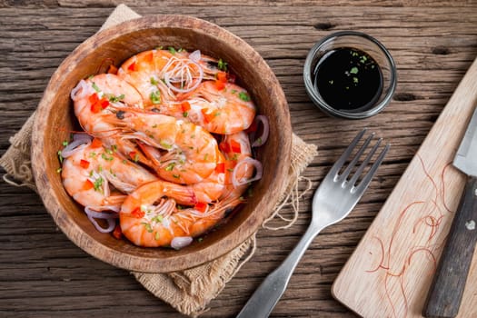steamed shrimps in a wooden bowl on wood background