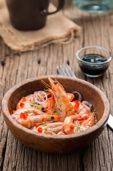 steamed shrimps in a wooden bowl on wood background
