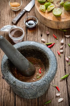 shrimp paste chilli sauce in a mortar stone with Ingredients to cook