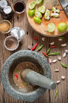 shrimp paste chilli sauce in a mortar stone with Ingredients to cook