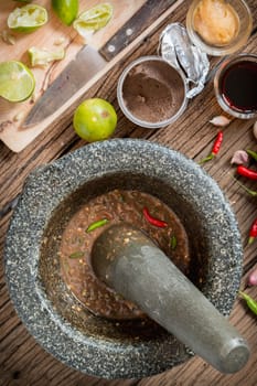shrimp paste chilli sauce in a mortar stone with Ingredients to cook