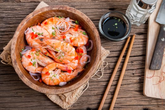 steamed shrimps in a wooden bowl on wood background
