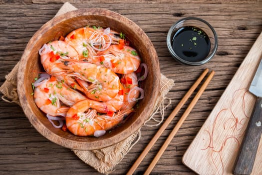 steamed shrimps in a wooden bowl on wood background