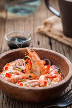 steamed shrimps in a wooden bowl on wood background