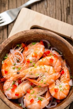 steamed shrimps in a wooden bowl on wood background