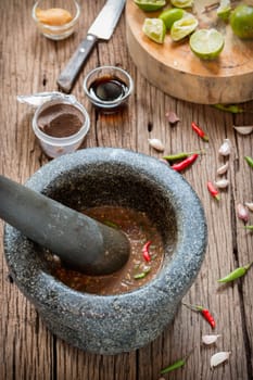 shrimp paste chilli sauce in a mortar stone with Ingredients to cook