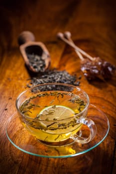 Cup of green tea with dried tea leaves
