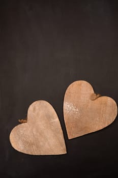 Two wooden heart shapes on a chalkboard