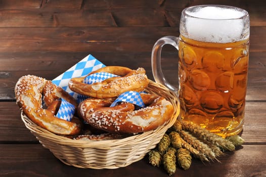 original Bavarian lye pretzels with salt in a basket on wooden boards with beer