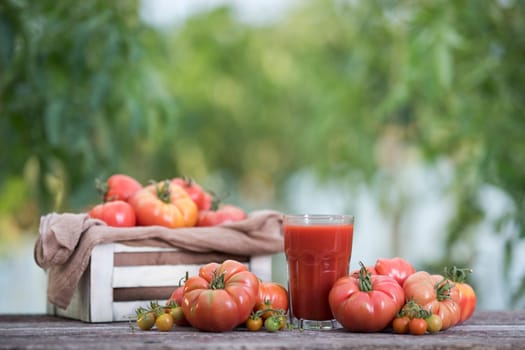 Fresh red tomato juice, on a wooden background