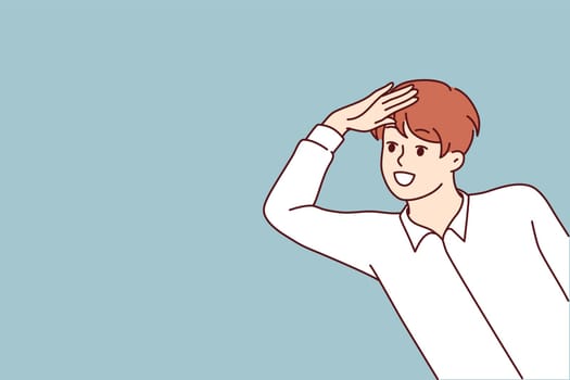 Boy looks out and puts hand to forehead to look into distance and find interesting offer or close person. Positive teenage boy smiling and playing spy or detective watching friends