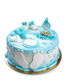 White and blue colored cake with a sleeping baby on top and some feet with booties for a baby's birthday isolated on white