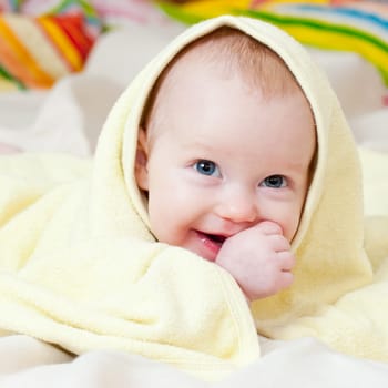 Cute little baby girl wrapped in yellow towel