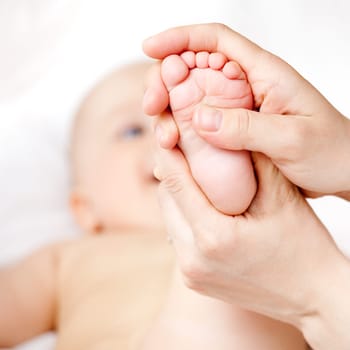 Mother massaging her child's foot, shallow focus
