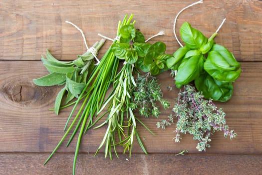 Freshly harvested herbs on wooden background