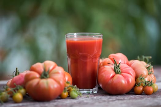 Fresh tomato juice, on a wooden background