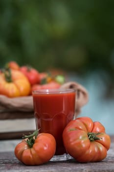 Fresh red tomato juice, on a wooden background