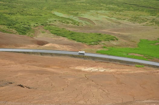 Aerial view of a car on a lonely road in a valley near the high-temperature area in Hverir, Iceland