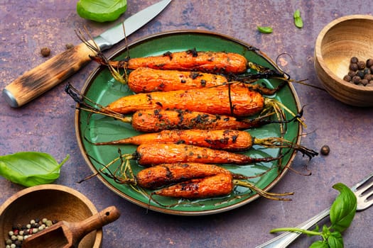 Baked with herbs and spices carrots. Tasty vegetable dish.