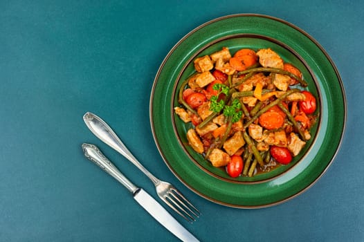 Stewed meat with carrots and green beans. Hot ragout with meat and vegetables.