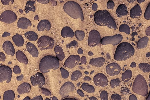 Directly above shot of lava stones in the sand of Famara beach in Lanzarote.
