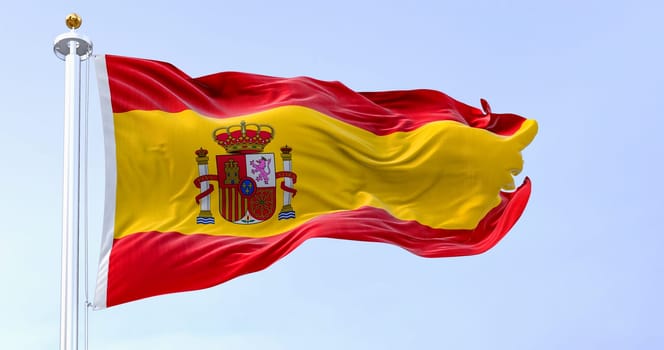 The national flag of Spain waving in the wind in a clear day. European country. Three horizontal stripes in red, yellow, red, coat of arms on the left. 3d illustration render. Rippled textile.